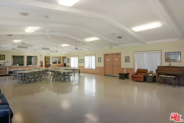 a living room with furniture and a dining table with wooden floor