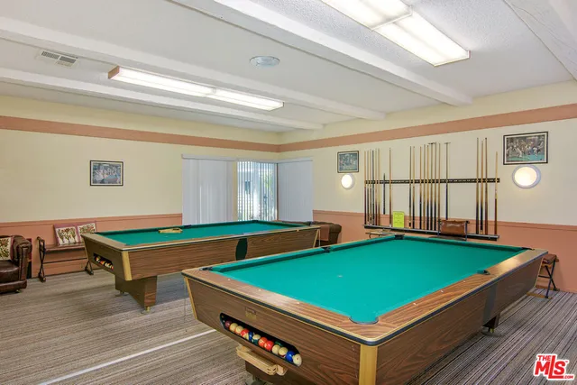 a room with pool table and windows