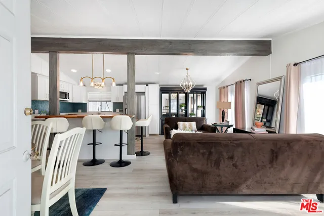 a living room with furniture kitchen view and a large window