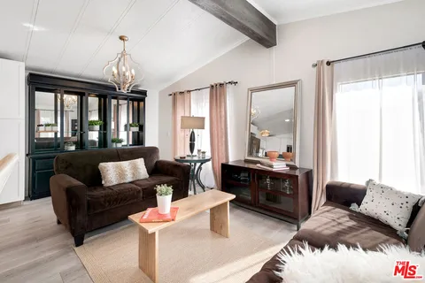 a living room with furniture fireplace and a large window