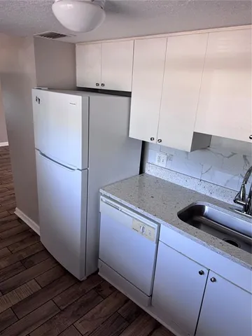 a view of a kitchen with refrigerator and window