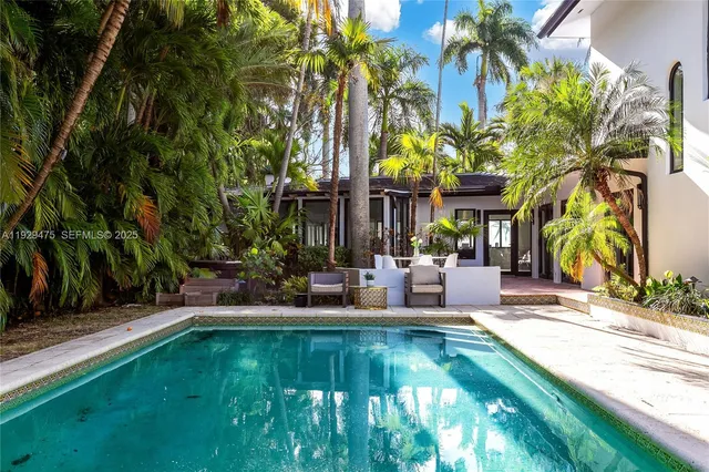 a view of a house with swimming pool and sitting area