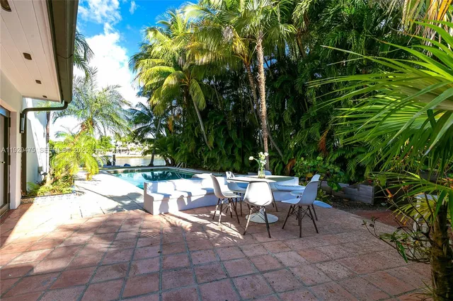 a view of a patio with a table and chairs and potted plants
