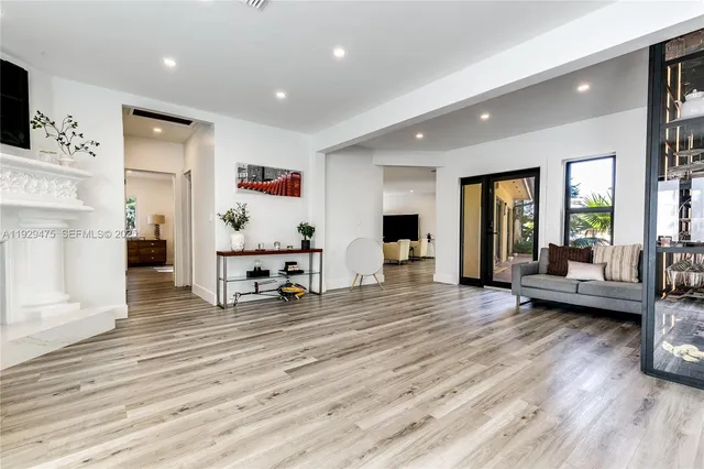a living room with furniture and a table with wooden floor