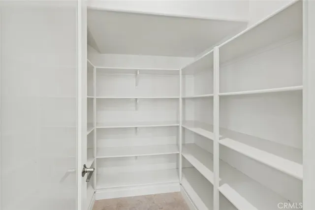 an empty room with chandelier cabinet and windows