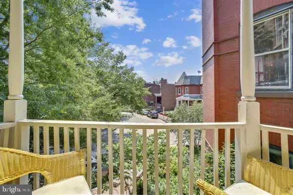 a view of a balcony with wooden floor and fence