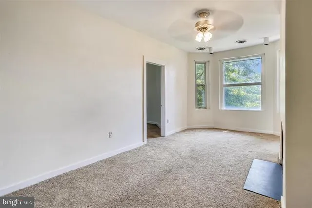 an empty room with windows and closet