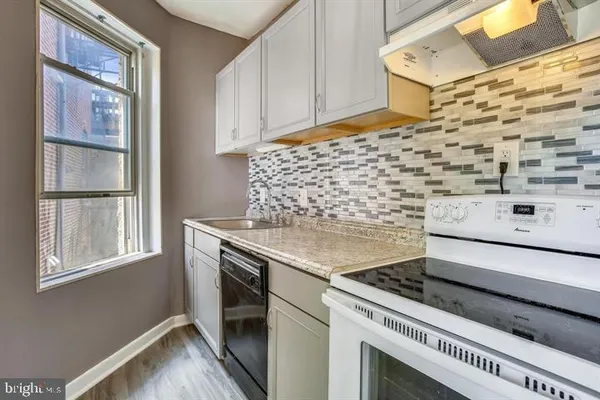 a bathroom with a stove a sink and a window