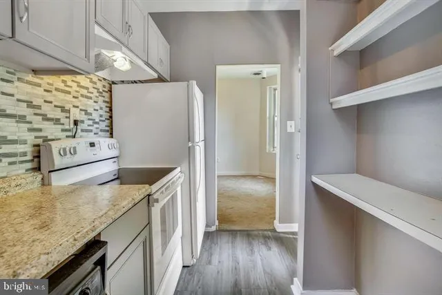 a kitchen with stainless steel appliances granite countertop a refrigerator and a stove