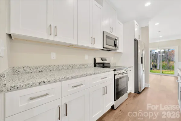 a kitchen with stainless steel appliances granite countertop a sink and a white cabinets