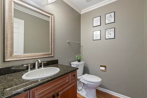 a bathroom with a granite countertop toilet sink and mirror