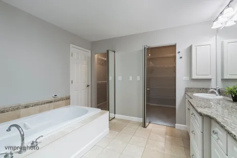 a spacious bathroom with a granite countertop sink and a mirror