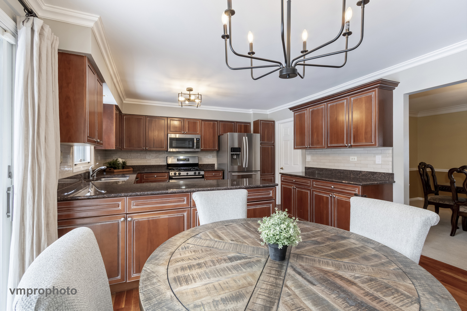 246 Montclair Road Vernon Hills, IL 60061 - Photo 7 of 50 a kitchen with stainless steel appliances granite countertop a stove sink refrigerator dining table and chairs