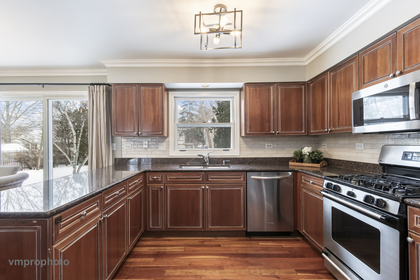 246 Montclair Road Vernon Hills, IL 60061 - Photo 9 of 50 a kitchen with stainless steel appliances granite countertop wooden cabinets stove top oven and sink