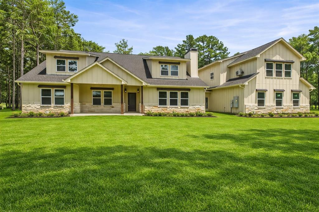 a front view of a house with a garden and trees