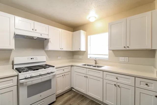 a kitchen with white cabinets and white appliances