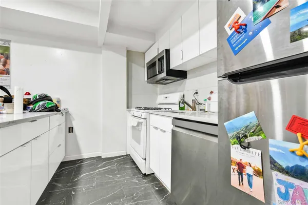 a kitchen with stainless steel appliances white cabinets and a window