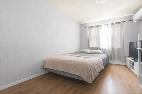 a bedroom with a bed tv and a window
