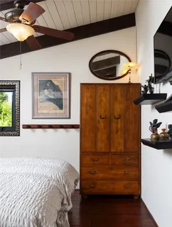 a bedroom with a bed and a painting on the wall