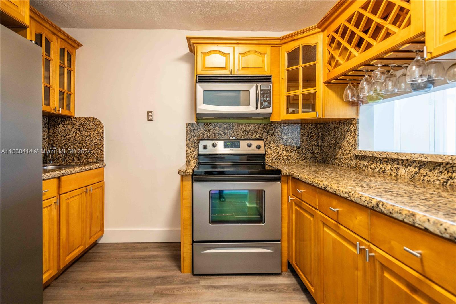 1945 Northwest 29th Street, Unit 8 Miami, FL 33142 - Photo 12 of 31 a kitchen with stainless steel appliances granite countertop a stove and a sink