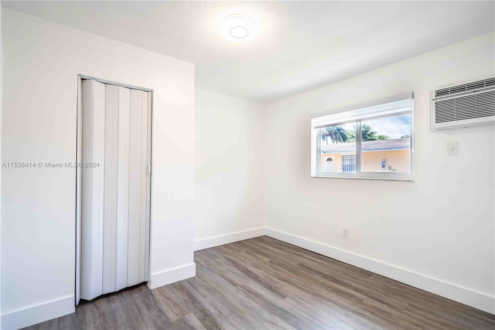 1945 Northwest 29th Street, Unit 8 Miami, FL 33142 - Photo 13 of 31 an empty room with wooden floor and window