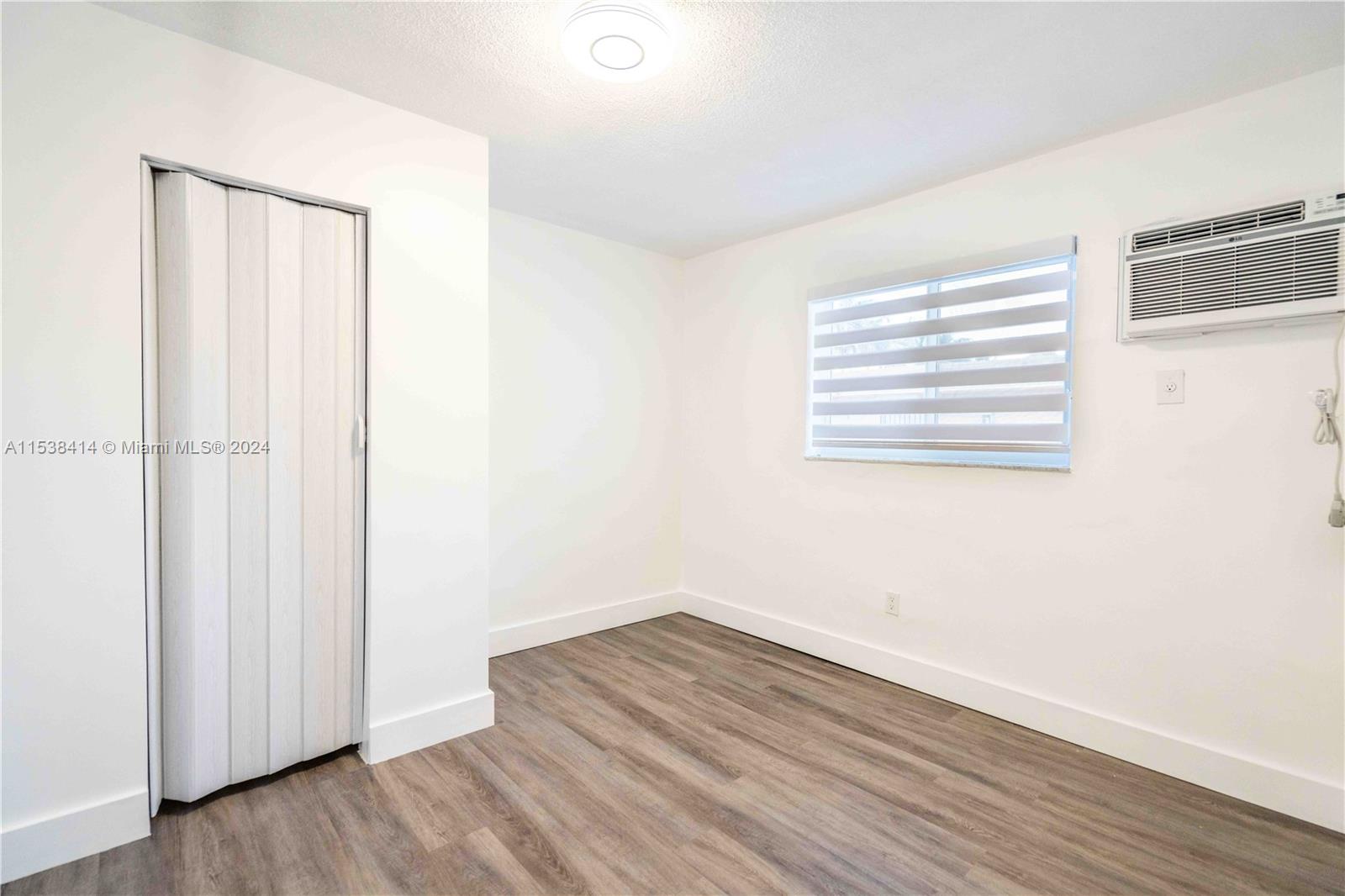 1945 Northwest 29th Street, Unit 8 Miami, FL 33142 - Photo 14 of 31 a view of a room with wooden floor and a window