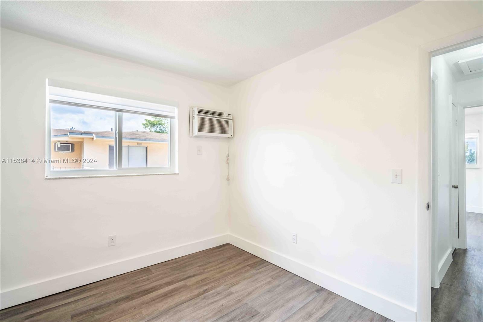 1945 Northwest 29th Street, Unit 8 Miami, FL 33142 - Photo 15 of 31 a view of empty room with wooden floor and fan