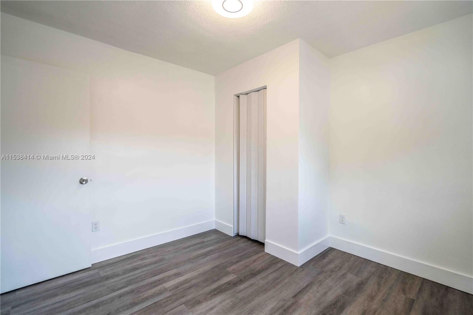 1945 Northwest 29th Street, Unit 8 Miami, FL 33142 - Photo 18 of 31 a view of an empty room with wooden floor