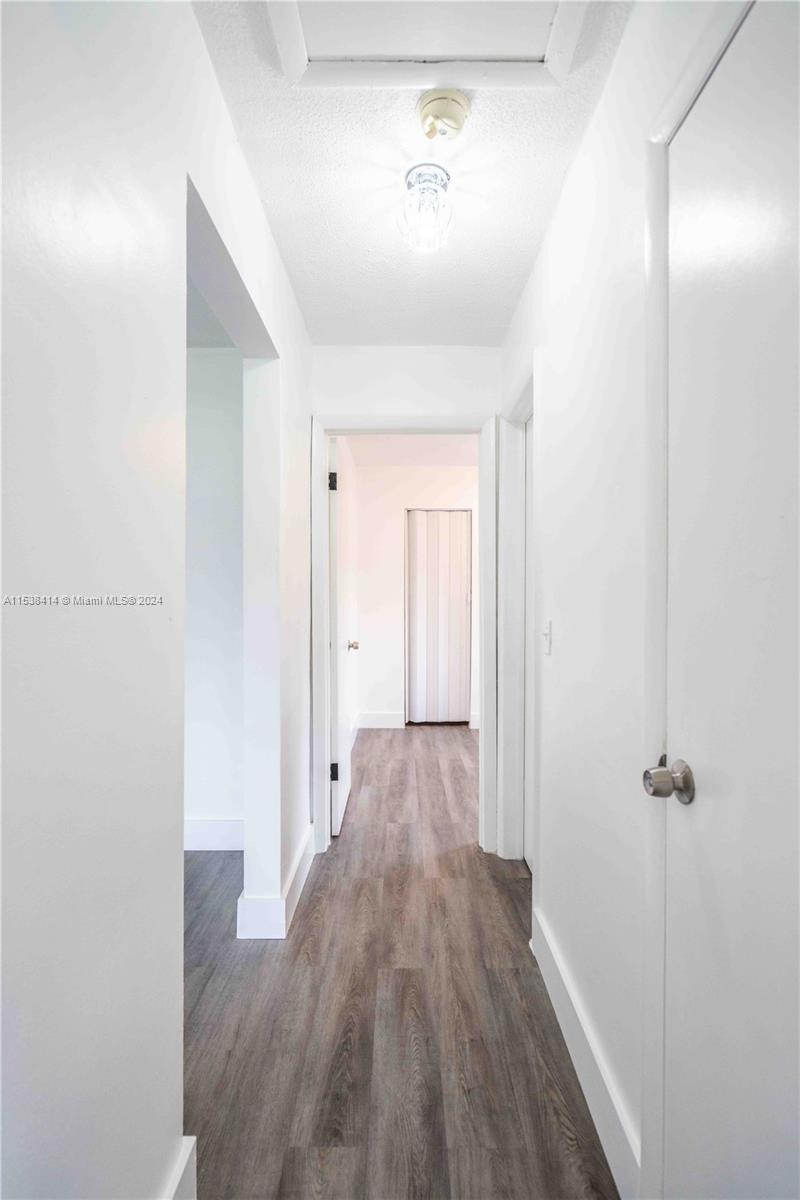 1945 Northwest 29th Street, Unit 8 Miami, FL 33142 - Photo 19 of 31 a view of hallway with wooden floor