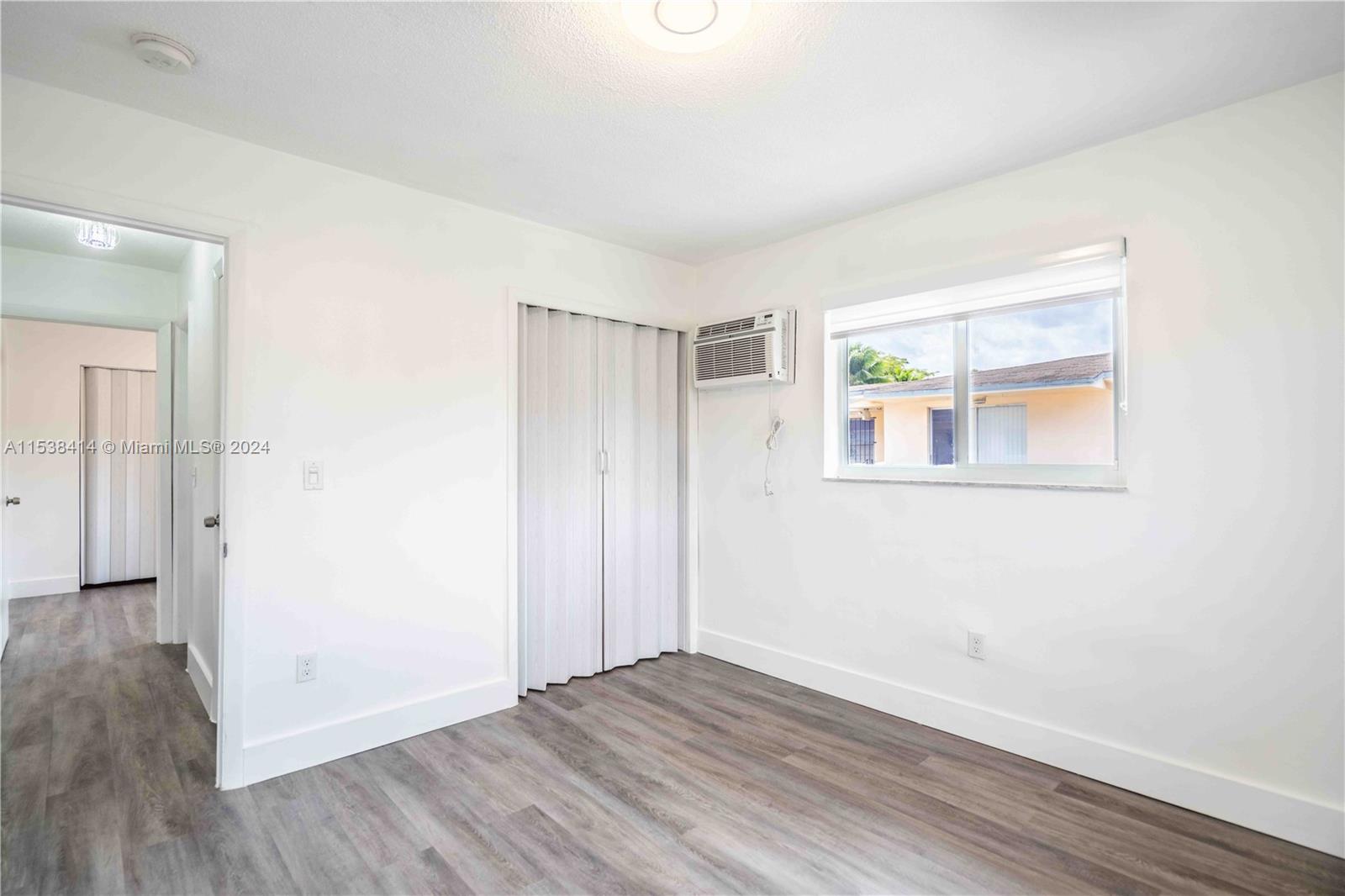 1945 Northwest 29th Street, Unit 8 Miami, FL 33142 - Photo 22 of 31 an empty room with wooden floor and windows
