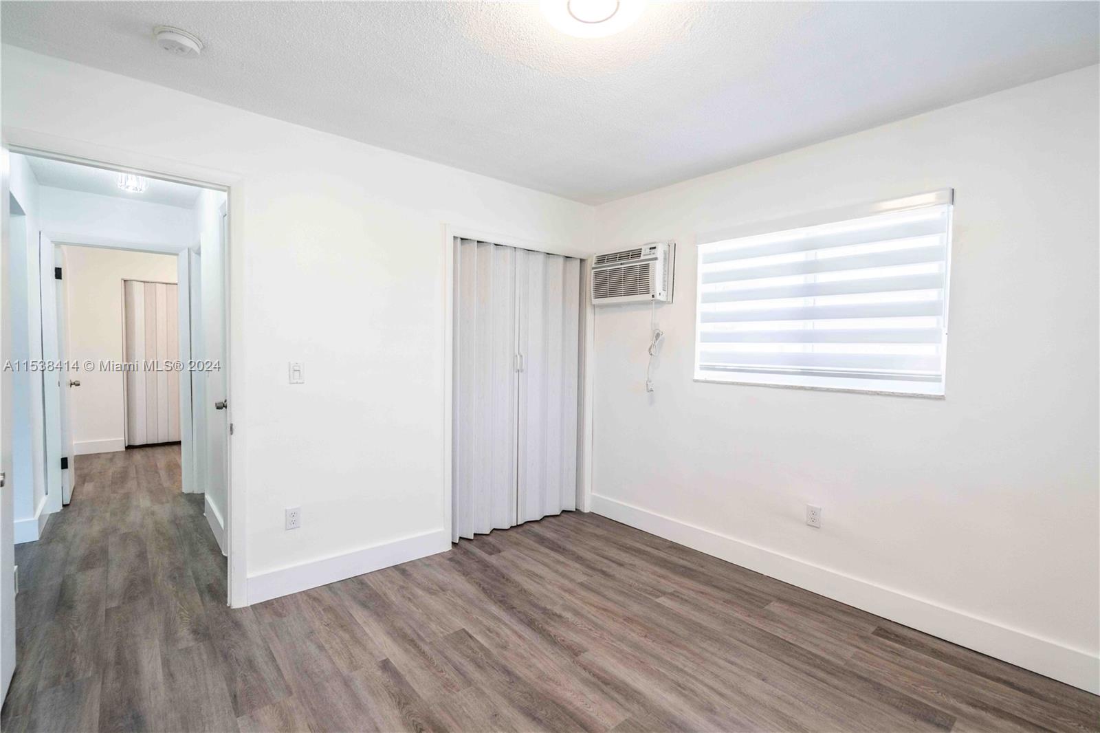 1945 Northwest 29th Street, Unit 8 Miami, FL 33142 - Photo 23 of 31 an empty room with wooden floor and windows