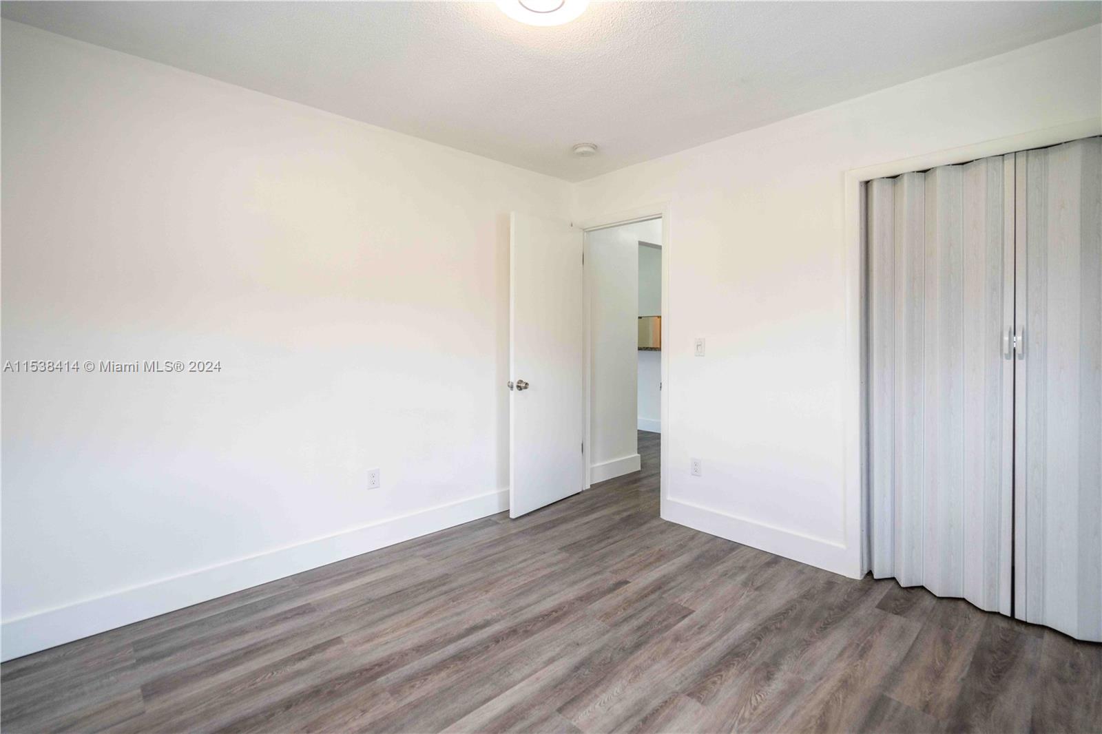 1945 Northwest 29th Street, Unit 8 Miami, FL 33142 - Photo 24 of 31 a view of an empty room with wooden floor