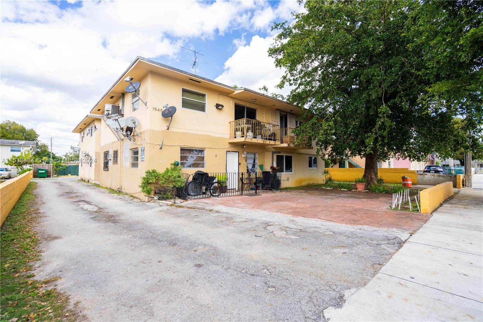 1945 Northwest 29th Street, Unit 8 Miami, FL 33142 - Photo 3 of 31 a view of a large building with large trees