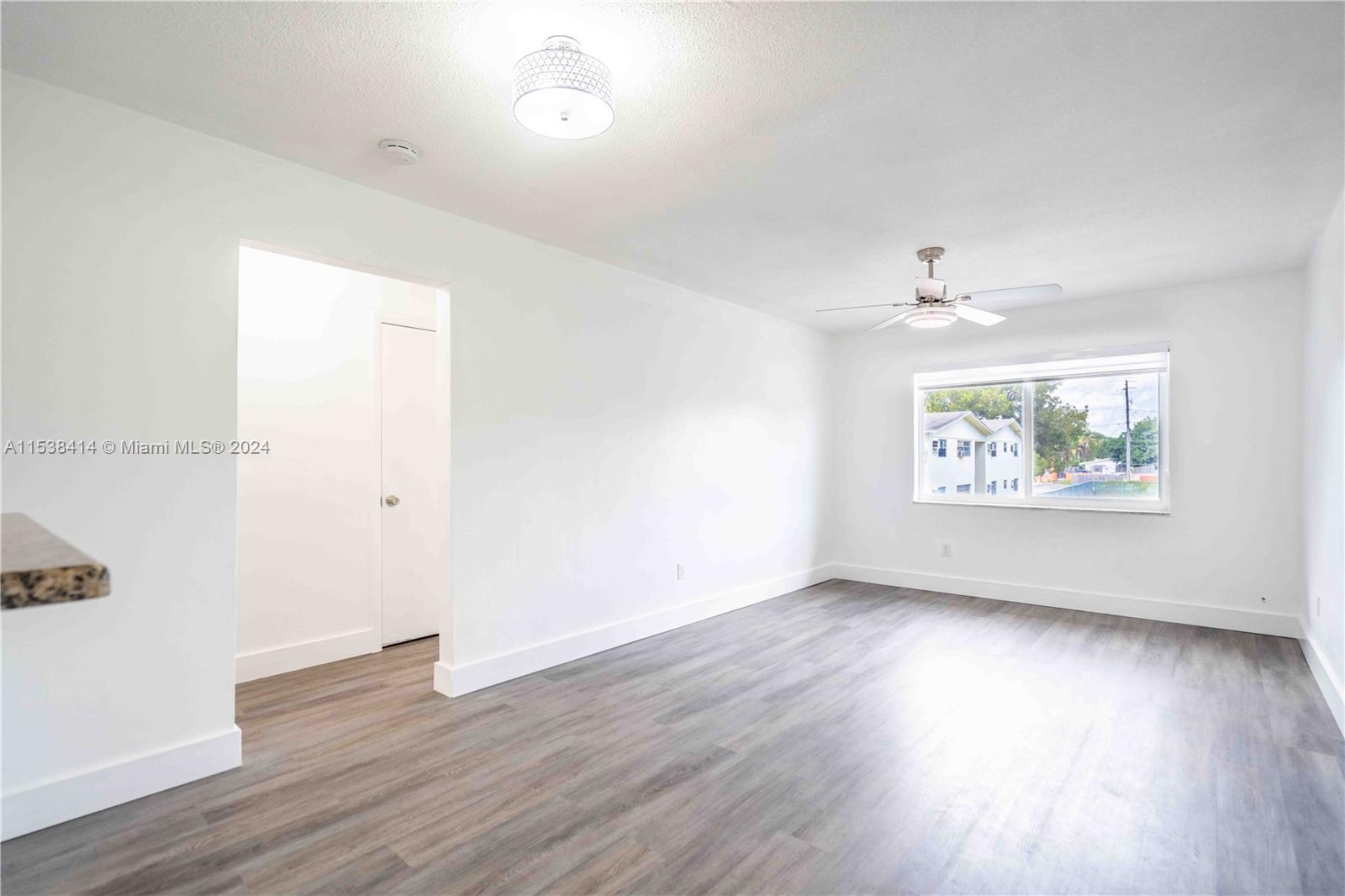 1945 Northwest 29th Street, Unit 8 Miami, FL 33142 - Photo 4 of 31 an empty room with wooden floor and window