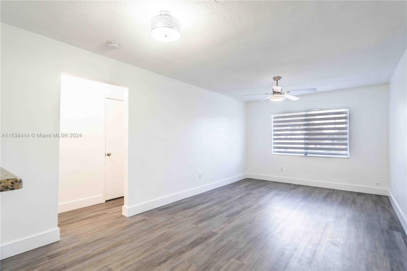 1945 Northwest 29th Street, Unit 8 Miami, FL 33142 - Photo 5 of 31 an empty room with wooden floor and windows