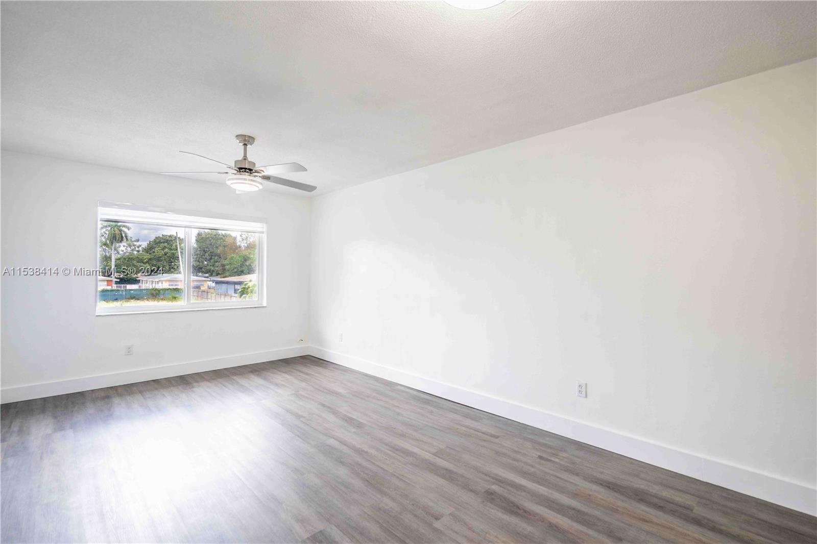 1945 Northwest 29th Street, Unit 8 Miami, FL 33142 - Photo 6 of 31 an empty room with wooden floor and windows