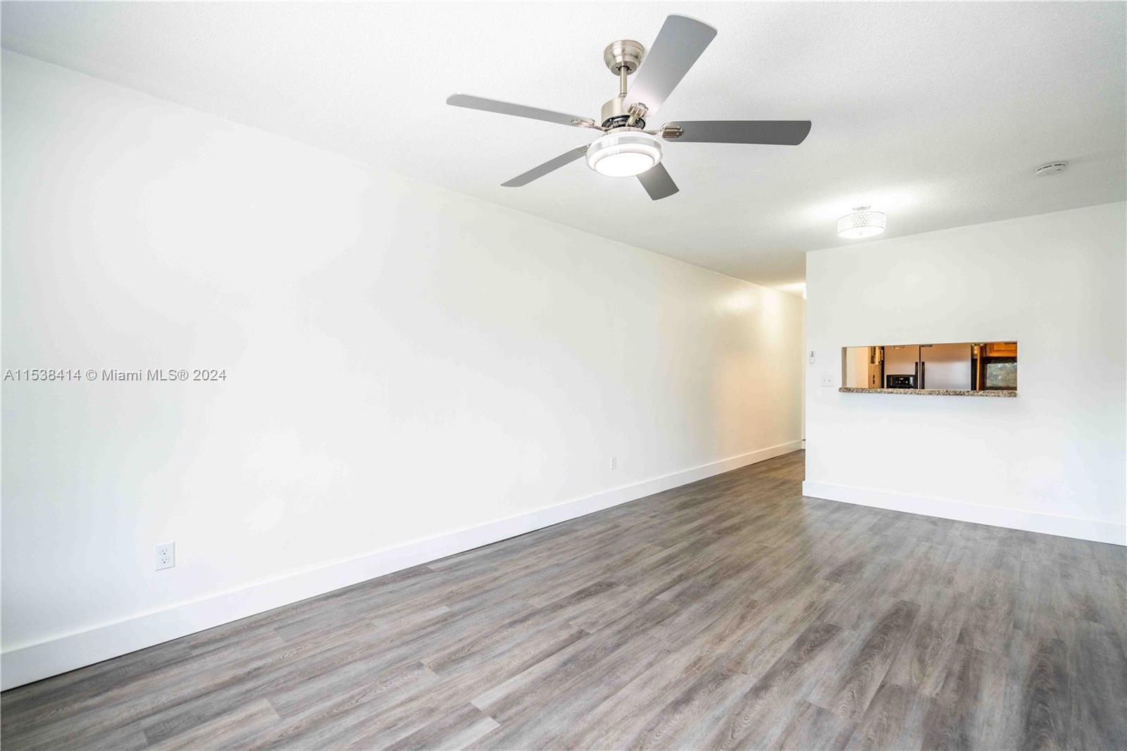 1945 Northwest 29th Street, Unit 8 Miami, FL 33142 - Photo 8 of 31 a view of a room with wooden floor and a ceiling fan