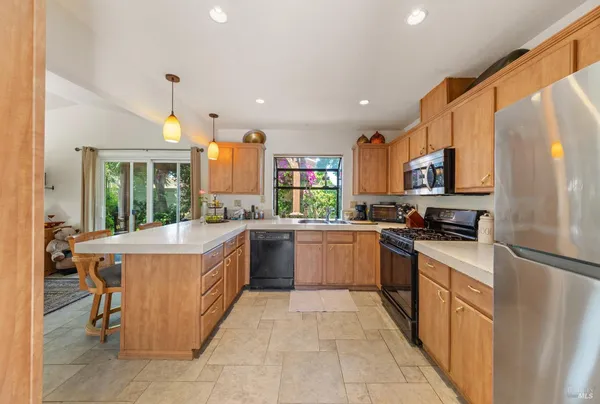 a large kitchen with stainless steel appliances granite countertop a large stove a sink and a refrigerator