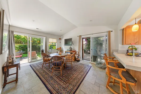 a living room with furniture a rug potted plant and a large window
