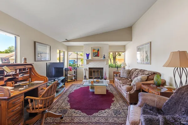 a living room with furniture a fireplace and a flat screen tv