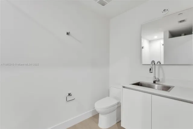 a bathroom with a sink a toilet and a mirror