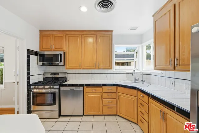 a kitchen with stainless steel appliances granite countertop a stove a sink and a microwave