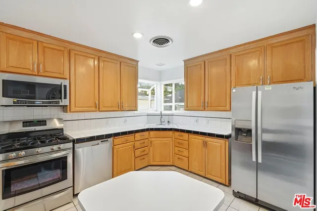 a kitchen with stainless steel appliances a stove a sink and a microwave