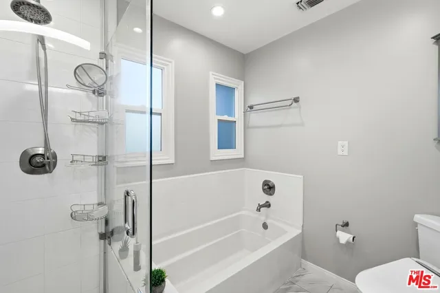 a bathroom with a bathtub a toilet and a shower