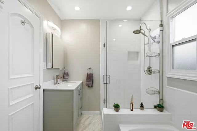 a bathroom with a tub sink and mirror