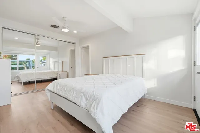 a spacious bedroom with a bed and a large window