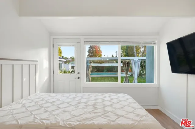 a bedroom with a bed and a flat screen tv