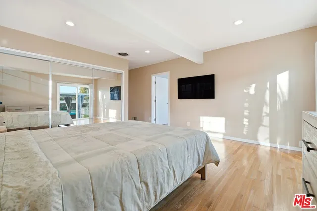 a bedroom with a bed and a flat screen tv