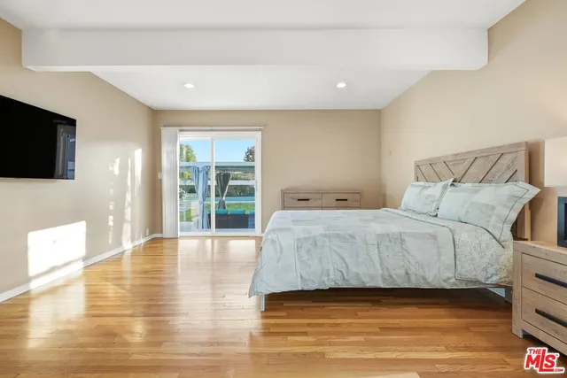 a spacious bedroom with a bed and a flat screen tv