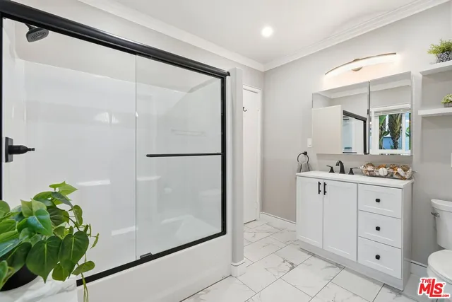 a view of an empty walk in closet and a bathroom